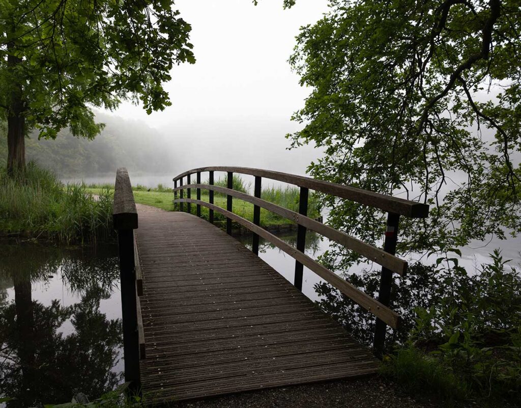 pov walking over wood slat bridge